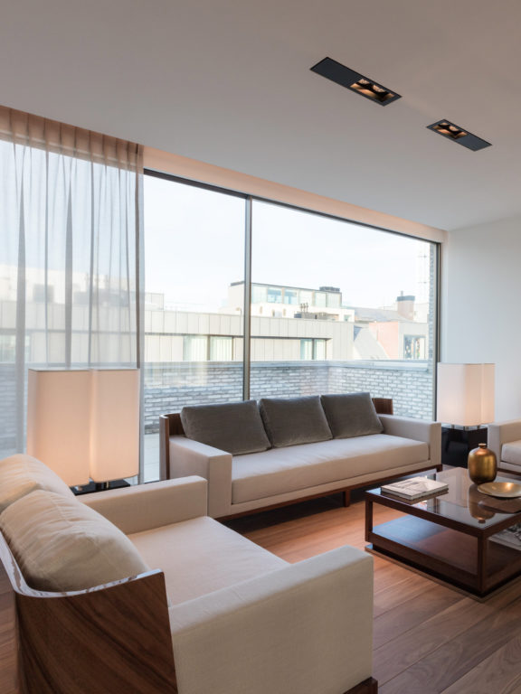 Aufnahme eines modernen Wohnzimmers mit zwei Brasilia LH Stehlampen von Michel Boyer und zwei Regard S Deckenleuchten von Glenn Sestig