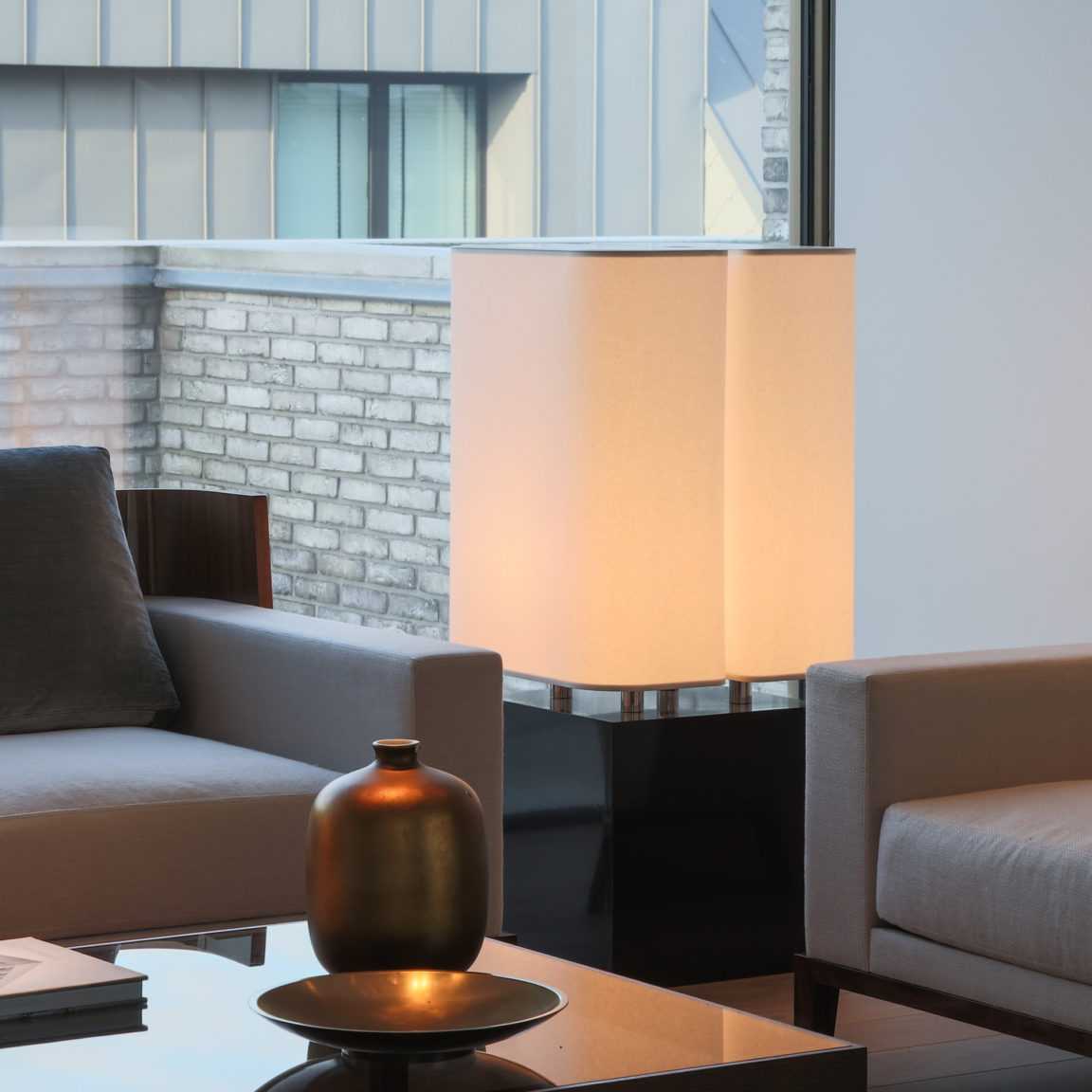 Die Brasilia LH Stehlampe von Michel Boyer steht im Wohnzimmer eines Hauses und beleuchtet den Raum.