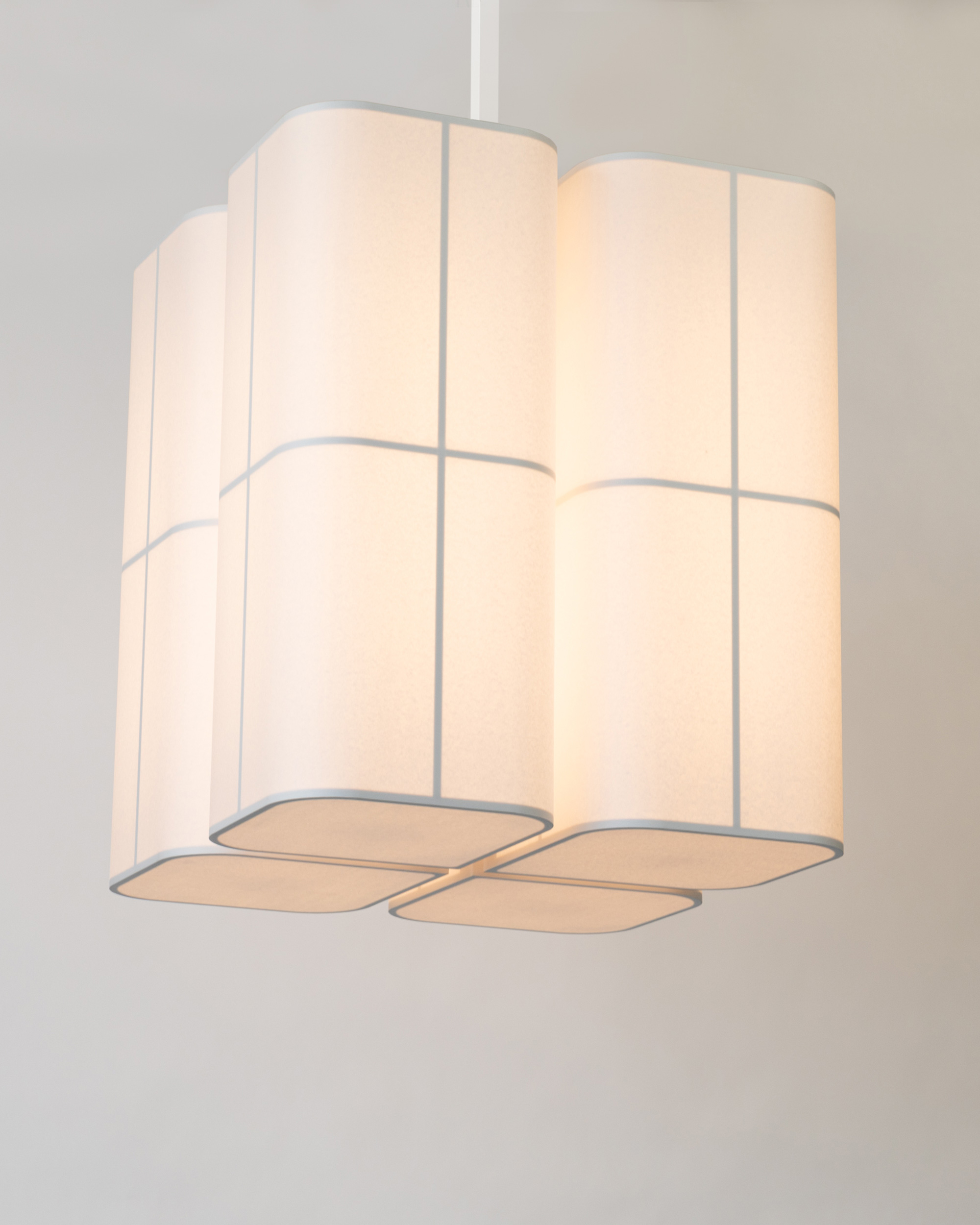 Avec ses quatre grandes parties, le lustre Brasilia PL en papier de Michel Boyer blanc diffuse une lumière chaude et douce