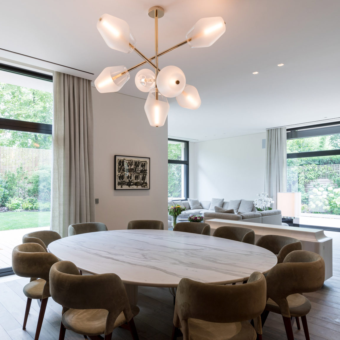 Le lustre Opéra de Régis Botta surplombe une grande table ronde face à une large baie