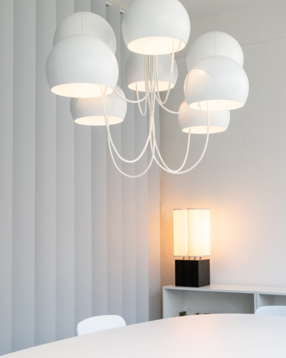 Der Kronleuchter Paulin M101 vor der Tischlampe Brasilia LP von Michel Boyer für Ozone