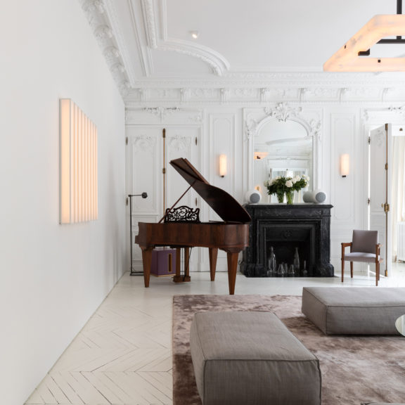 Living room of the project Appartement Lumière with 9 Lines, Embrun A sconce and Embrun L chandelier all by Ozone.
