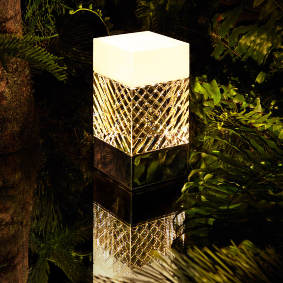 La lampe à poser en cristal de Ozone Light et Ateliers Saint-louis comme posée sur l'eau au milieu d'une forêt