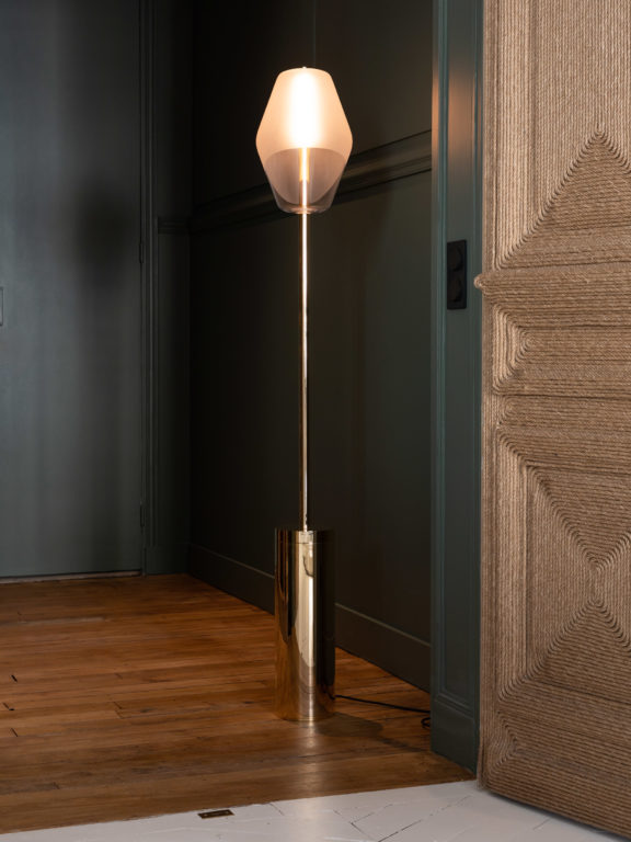 Regis Botta's Montmartre street lamp in front of a forest green wall and a wicker door