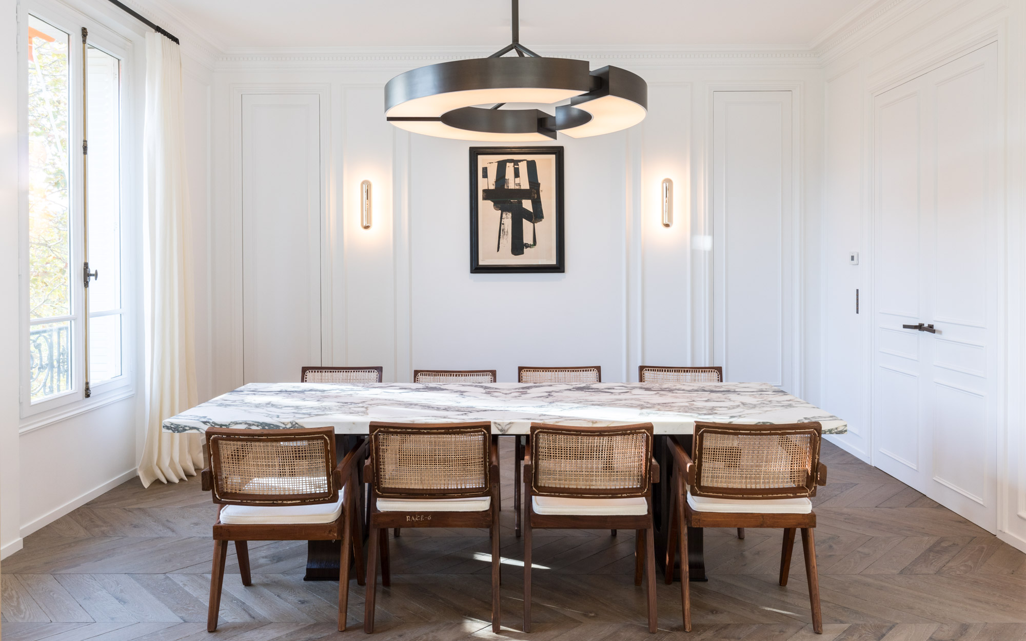 The Classique V chandelier and the Gélule sconces illuminate the dining room of an appartement with view on Les invalides, Paris