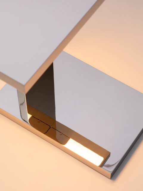 Zoom auf die Lichtreflexion der Tischleuchte LP Ozone auf ihrem Sockel aus verspiegeltem Nickel