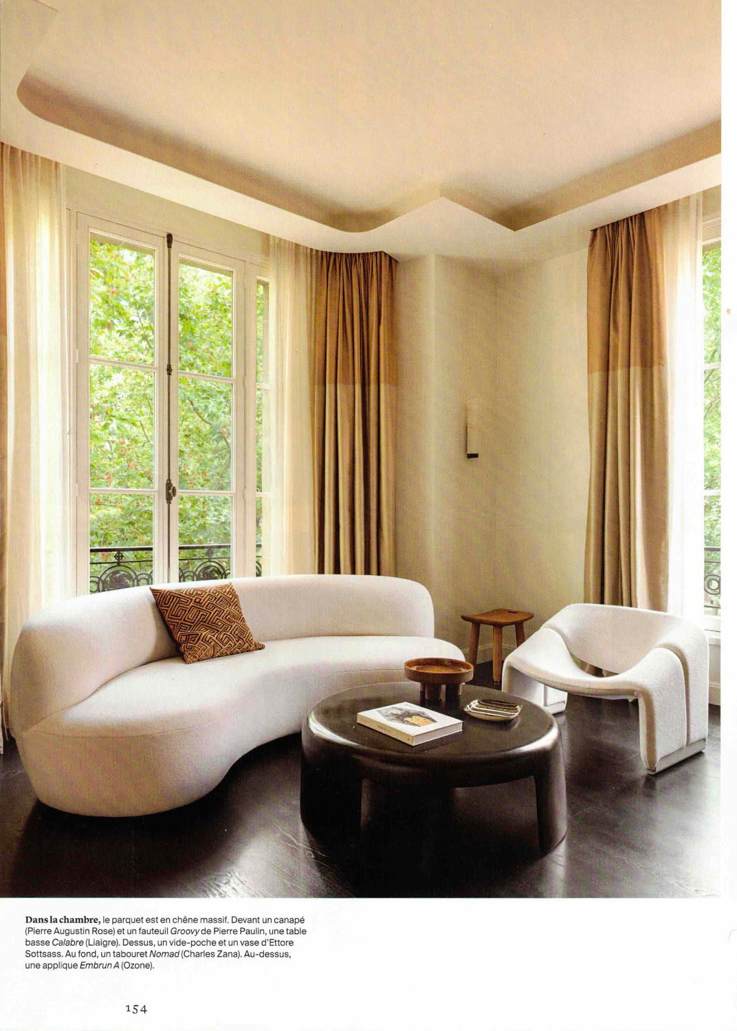 Page from AD magazine featuring a beige-toned living room. A wall light from Ozone's Embrun collection takes pride of place on the wall.