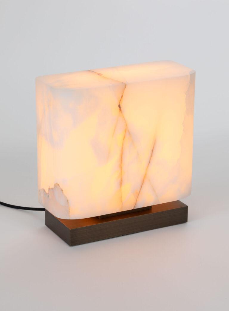 Lampe à poser Embrun LP en Onyx blanc et laiton sur un fond blanc