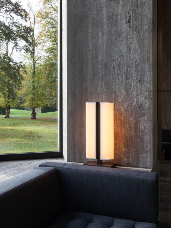 Lampe à poser Tennessee LP face à une baie vitrée dans une villa sombre.