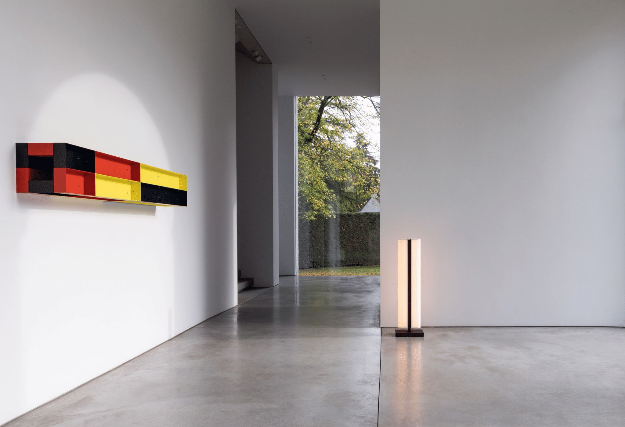 Image of the Tennessee floor lamp in a bright gray hallway with colorful artwork in the Tennessee 2026 booklet