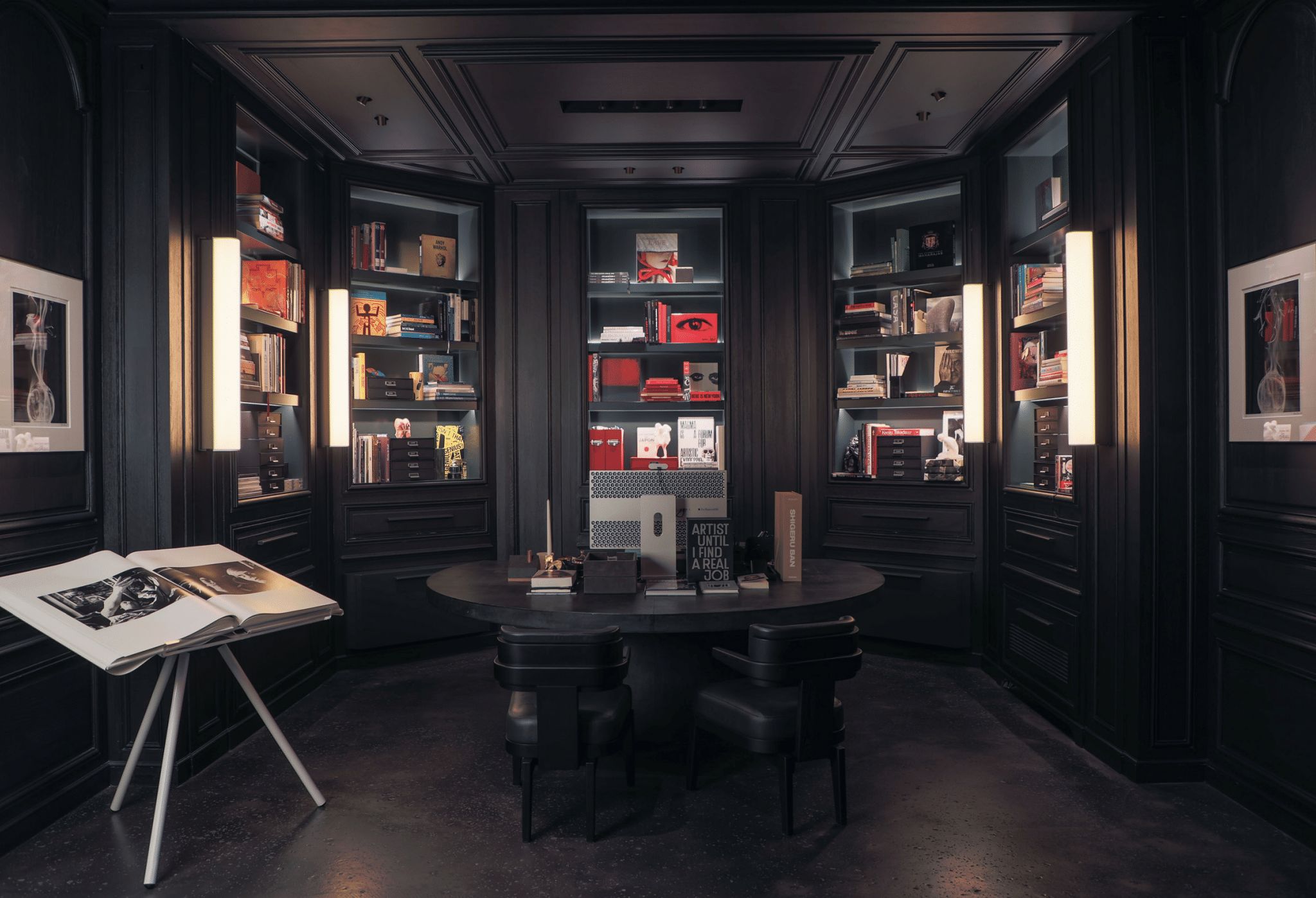 Four Tennessee sconces illuminate a large dark bookcase.