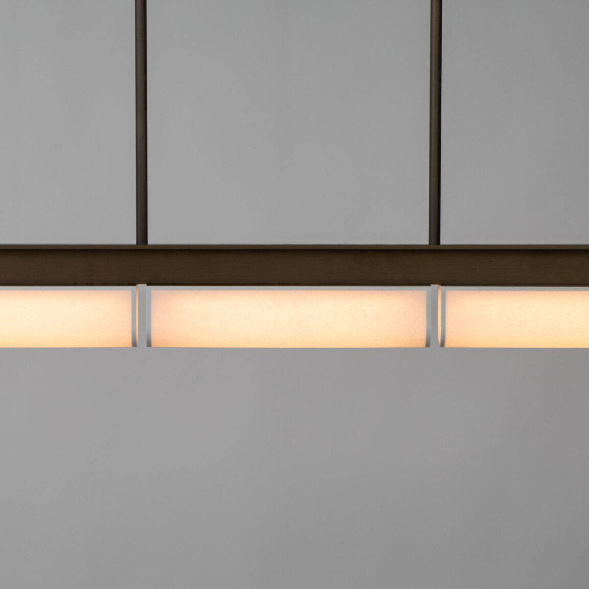 The geometric lines of the Tennessee PL3 pendant light in a white studio