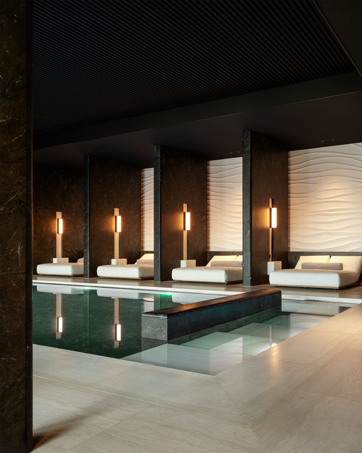 Dans le spa de l'hôtel La Reserve Resort à Knokke les quatre appliques Tennessee se suivent sur des murs en marbre noir