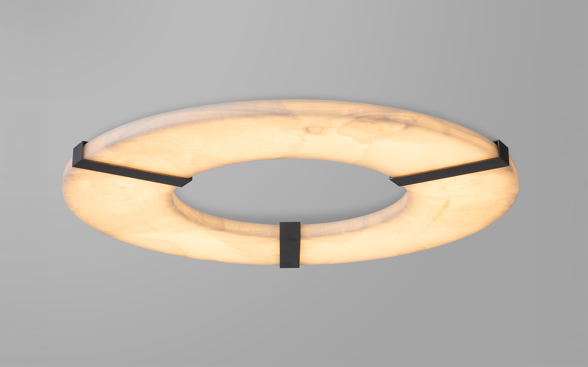 Le plafonnier Luxembourg C Onyx en onyx blanc fixé sur un plafond gris 