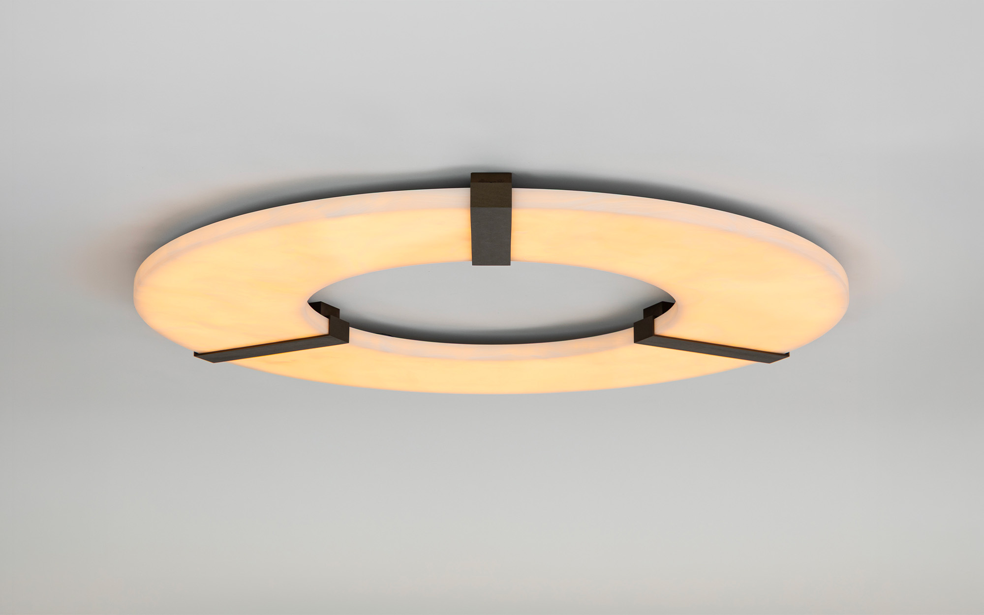 Le plafonnier Luxembourg C Onyx en onyx blanc fixé sur un plafond gris 