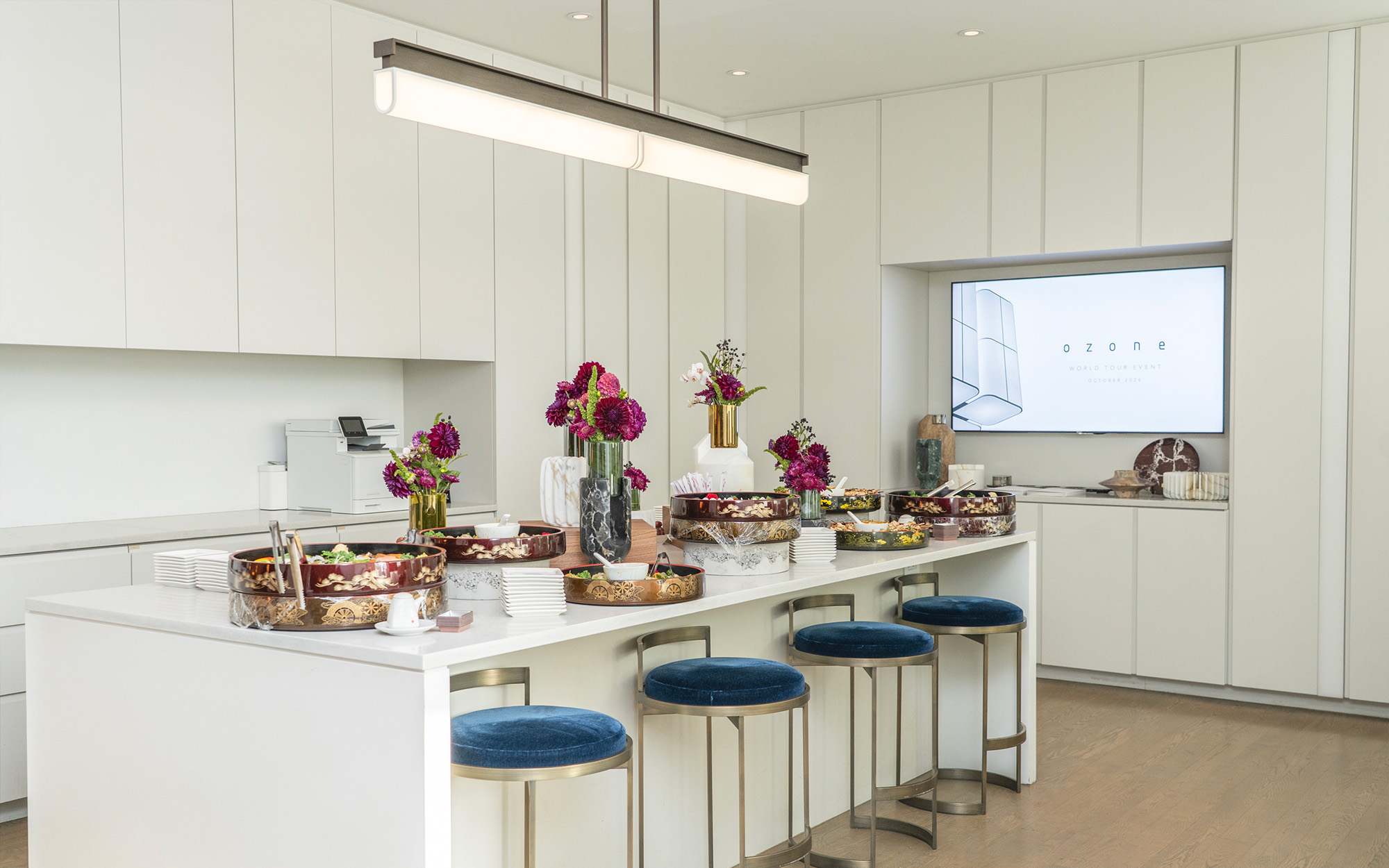 Hanging above a white kitchen is a Tennessee PL2 pendant light designed by Glenn Sestig for Ozone