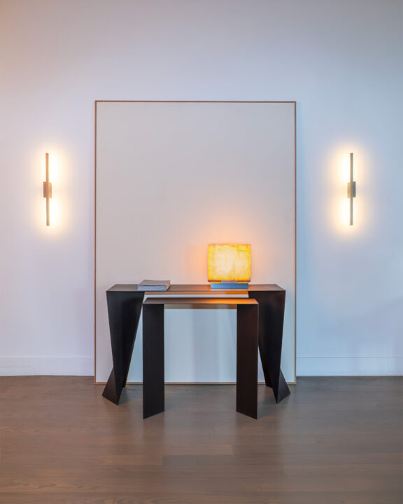 An Embrun LP is sitting on a black table flanked by two Untitled A wall sconces designed by Gounot&Jähnke